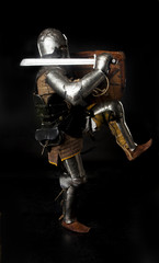 Medieval knight in full armor attacks