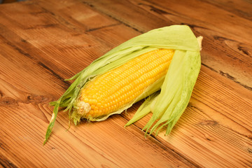 One open corn cob on vintage wooden surface