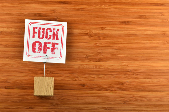 Fuck off paper note on bamboo wooden background