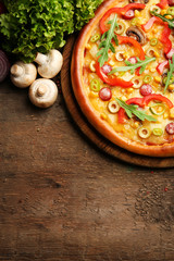 Delicious pizza with salad and Champignon on wooden background