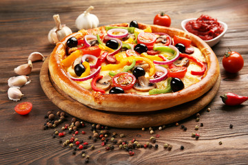 Delicious pizza with vegetables, on wooden table
