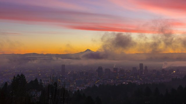 UHD Time Laspe movie of thick rolling fog and low clouds over city of downtown Portland Oregon and snow covered mt. hood one early morning at colorful sunrise during winter season 4096x2304