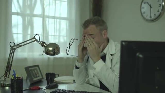 A man works at a clean desk with a computer