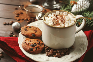Mug of hot chocolate with marshmallows, fir tree branch on wooden background