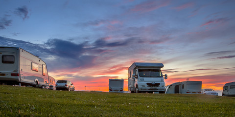 Caravans and cars campsite sunset - obrazy, fototapety, plakaty