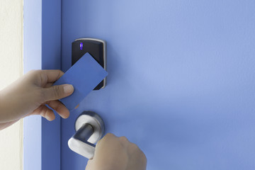 left hand hold key card touch on electronic pad lock access cont