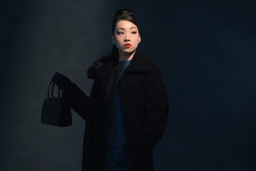 High society retro 1940 asian fashion woman. Holding handbag.