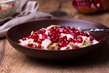 Healthy salad with pomegranate seeds, chicken and cabbage.