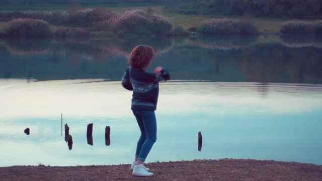 girl throwing rocks in the lake. Shot in slow motion
