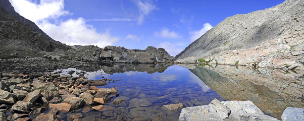 High altitude clear alpine lakes in the Rocky Mountains, as viewed from a mountain summit above while hiking and backpacking.