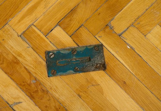 Steel locks for training equipment. Worn out wooden floor of sports hall