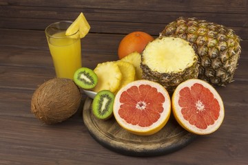 Red grapefruit and fruit for weight loss. Fresh dietary food for athletes. Fruit on a wooden table. Composition with variety of fresh fruits. Balanced diet. Assortment of exotic fruits. 
