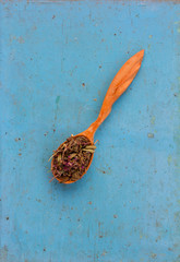 Dried herbsSalvia officinalis in a wooden spoon on the old blue board. Ingredient for cooking healthful beverage. The concept of rustic herbal therapy. Ingredient for cooking healthful beverage