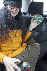 Girl dancing in a car with two cds