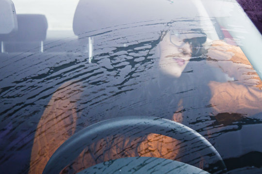 woman waiting in her car in a raining day