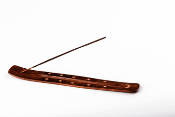 Incense stick on a wooden support on a white background