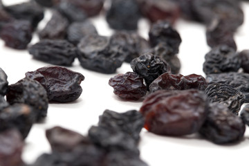 Black raisins on a white background. macro