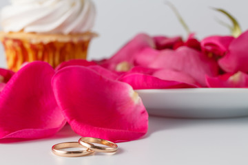 Obraz na płótnie Canvas Rose petals and wedding rings