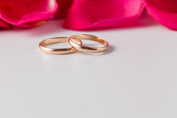 Golden wedding rings with rose petals