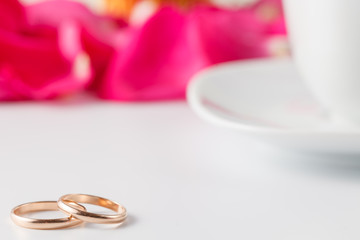 Golden wedding rings with rose petals
