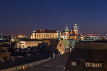 Obraz premium Royal castle and cathedral on the Wawel hill seen from the Town Hall tower in Krakow, Poland in the night