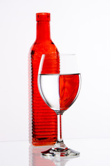 Red bottle and filled glass on white background