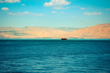 Brown wooden boat sailing in Sea of Galilee

