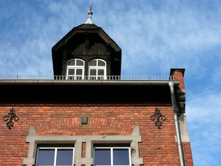 Dachgaube mit Sprossenfenster und schönem Giebel auf der Backsteinfassade der alten Dorfschule in...