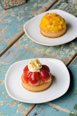 Strawberry Tart and mango Tart on a wooden table