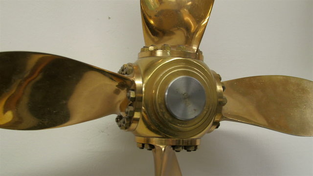 A small propeller in gold color. The ship propeller makes the ship move in the water