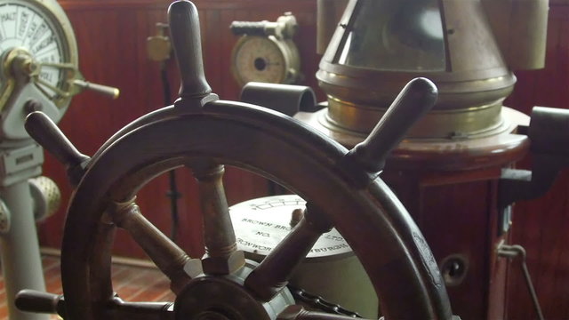 A wooden steering wheel on the captains deck. This helps in navigating in the ocean by the boatmen