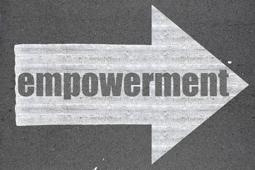 Arrow on asphalt road written word empowerment