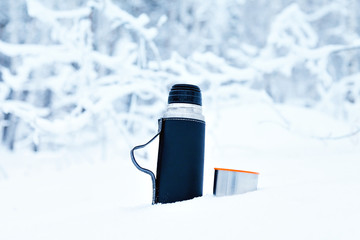 a thermos of hot tea in the forest