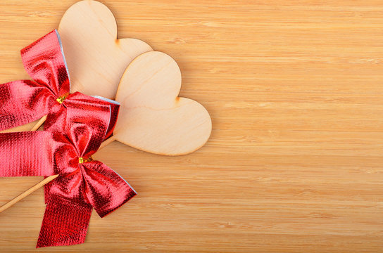 Heart with red bow on wooden background