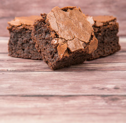 Homemade chocolate brownies over wooden background
