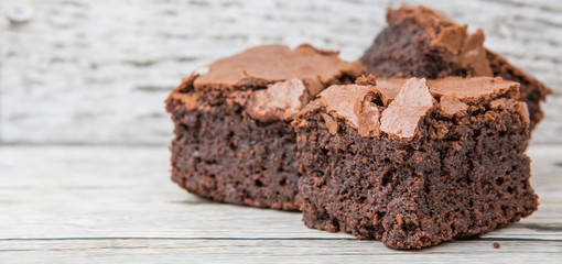 Homemade chocolate brownies over wooden background
