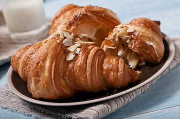 Croissant with almonds on blue wooden surface