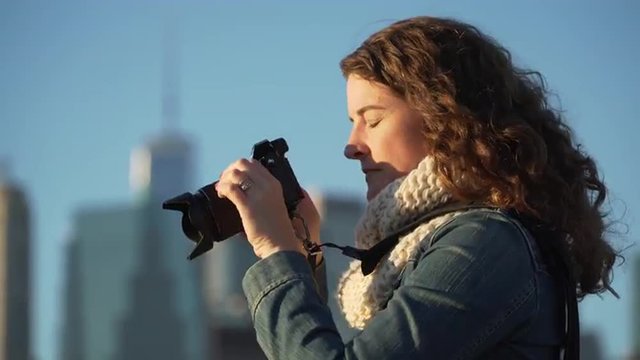 A woman takes pictures of NYC skyline