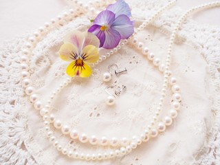 Fototapeta na wymiar 真珠のネックレスとイヤリングとビオラ