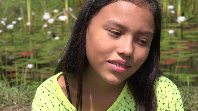 Young Girl Daydreaming near Pond