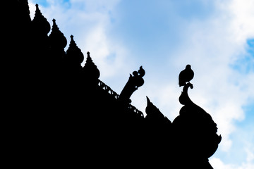 Silhouette of birds on roof.