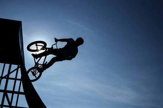 Extreme Silhouette man doing jump with a bmx bike.