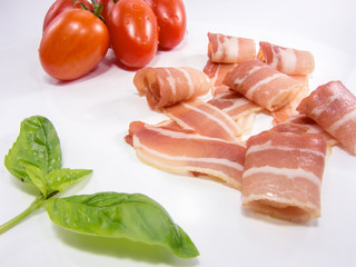 fresh snack of dry smoked ham tomato and basil isolated on white