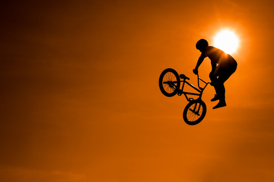 Extreme Silhouette man doing jump with a bmx bike.