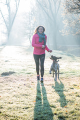 Runner woman and her cute German pointer dog running together outdoor at the beautiful park. 