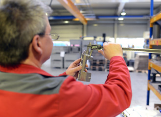 Techniker kontrolliert Werkstück mit einem Meßschieber im Metallbau