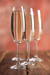 Glasses of champagne on red background