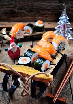 homemade sushi on small sleigh Christmas background, selective focus.