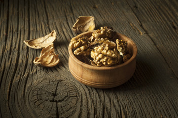 Walnut kernels and whole walnuts on rustic old wooden table
