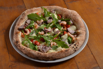 Pizza con ruccola y vegetales.